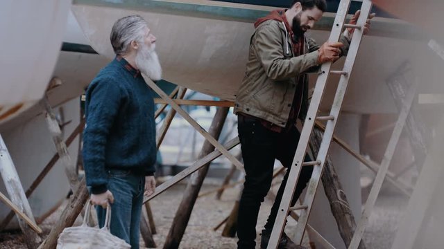  Boatyard carpenters checking boats which have been renovated or newly built. 