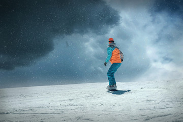 Woman on the snowboard in sport action at sunny day around mount