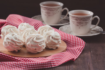 Marshmallow or zephyr with cups of tea on the red and white napkin