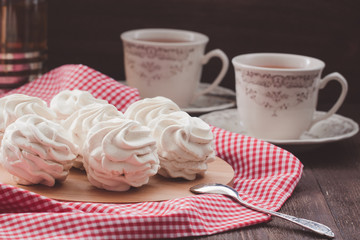 Marshmallow or zephyr with cups of tea on the red and white napkin