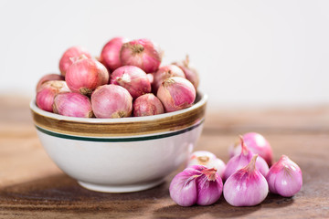 Fresh shallots in a bowl and wooden background, spice and herb, food ingredient © nungning20