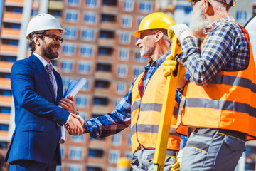 Construction worker and businessman shaking hands
