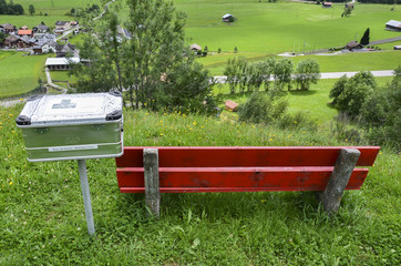 Red bench and a box full of books for hikers to sit and read
