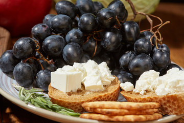 Cheese, vegetables, fruits and spices. Bread, olives and crackers. Mediterranean diet and cuisine. Dark background.