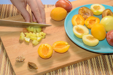 Hand cuts fruit on a wooden board