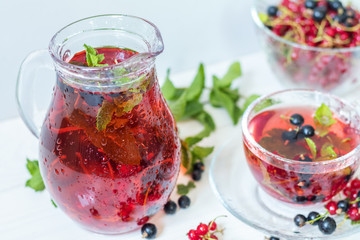 Fruit drink in transparent glass carafe and cup