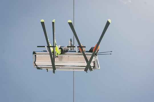 Skiers taking a chairlift in the alps.