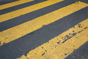 yellow pedestrians lines on a black road