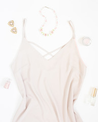 Beauty blog concept. Woman outfit. Pink dress, bracelets, necklace, earrings and cosmetics on white background. Trendy fashion feminine background. Fashion beauty background. Flat lay, top view