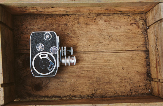 Vintage cinema camera inside an old wooden box