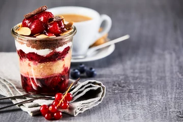 Keuken foto achterwand Dessert Gelaagd fruitdessert in pot met kopje koffie