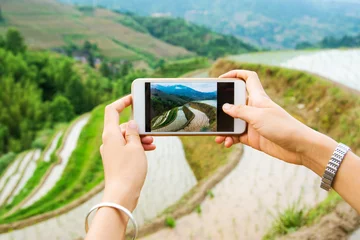 Gordijnen Girl capturing rice terrace scenery with a phone © creativefamily