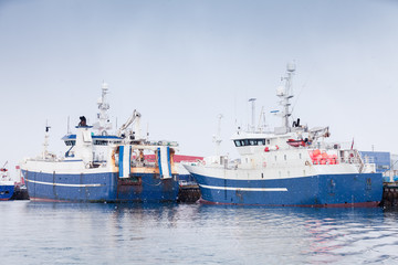 Fototapeta premium Industrial fishing ships. Blue white trawlers