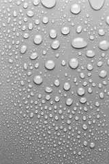 Surface with water drops, grey background.
