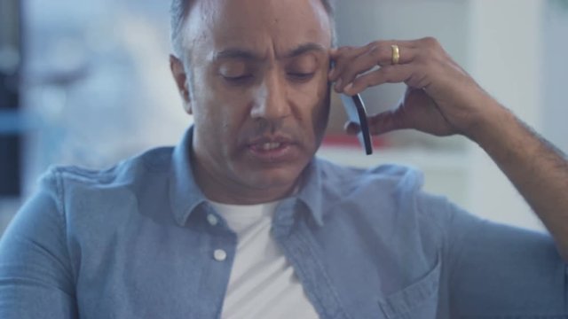 Close up  casual Asian man working on laptop and making a phone call