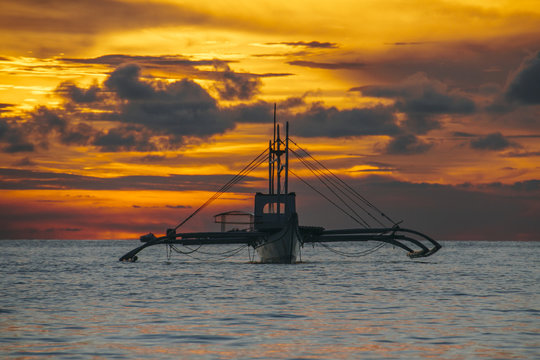 Traditional asian fishing boat on the sea at sunset