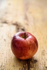 Red apple on rustic wooden background. Autumn fruit