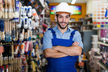 Man artisan with folded arms in paint store