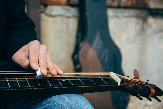 Closeup of A Male Musician's Hands Playing Slide Guitar