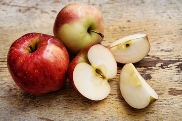 Naklejka na ściany i meble Bio apples with slice on rustic wooden background. Autumn fruits