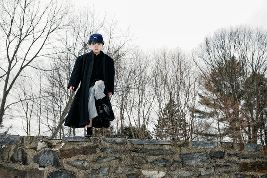 Boy pretending to be a Union soldier marches on a tall stone wall