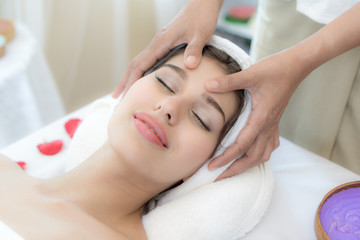 Fototapeta na wymiar beautiful and healthy young woman relaxing with face massage at beauty spa salon