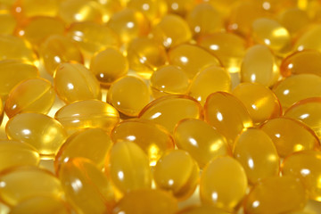 Omega-3 fish fat oil capsules as background texture.