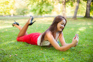 Pretty girl take selfie at grass in park outdoor with funny fase and good mood. 