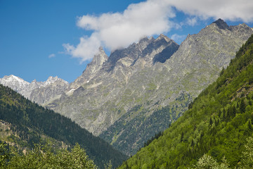 Fototapeta premium Wooded hills and mountains under the blue sky and clouds