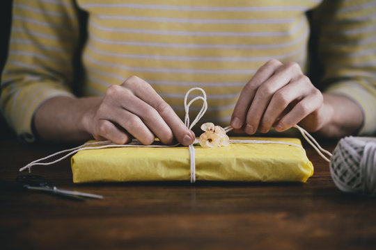 Hands gift wrapping a small present