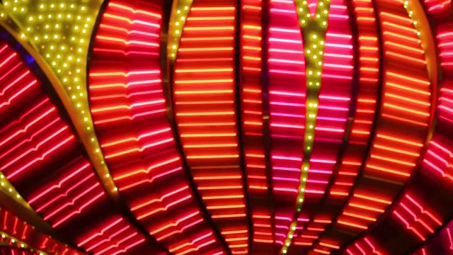 Defocused and focused red neon running lights in Las Vegas. Illuminated Night Red Neon Sign Nightlife Casino Lights Display Las Vegas Strip. Las Vegas Neon Lights. Neon flashing lights of Las Vegas.