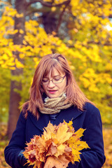 Naklejka na ściany i meble Portrait of woman in an autumn park.