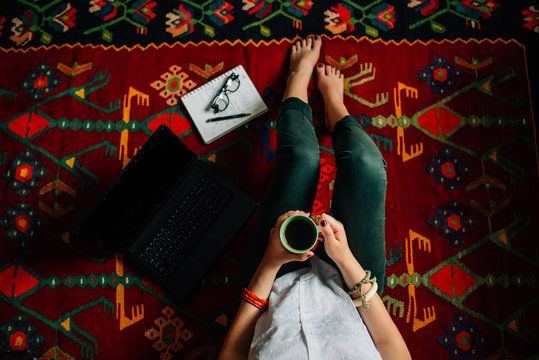 Woman sitting on the floor and working on a laptop