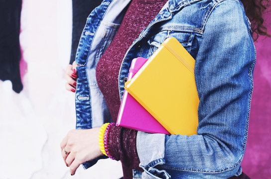 Girl In Denim Jacket With Colorful Diaries In Her Hands