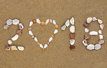 Fototapeta na wymiar Pebble New Year 2018 number with shell heart shape on wet sandy beach.Summer 2018 holidays concept.