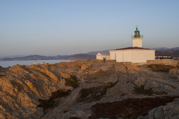 Fototapeta na wymiar Corsica, 30/08/2017: tramonto al Faro della Pietra, inaugurato nel 1857 sulla cima dell'Isola della Pietra, il promontorio roccioso di Isola Rossa, famosa città dell'Alta Corsica