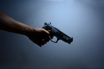 the killer man,a man holding a gun in darken light
