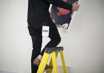 Man taking care of frames in an exhibition