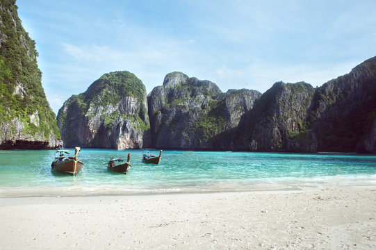  Beach with white sand landscape. Boat mooring in Asian style, canoe. Phi Phi Ley Thailand