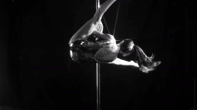 amazing pole dancer showing her skills against a black background