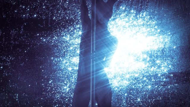 amazing pole dancer showing her skills against sparkling blue background