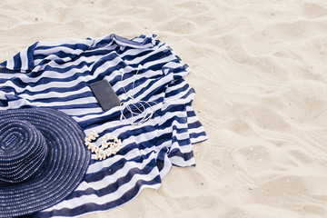 summer composition with hat, flops and sunglasses on a sand beach