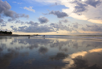 Mirror reflection of the sunset on Kuta beach. The island of Bali. Indonesia.