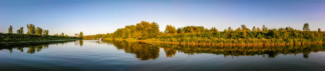 Panoramic view of a river with boat at anchor