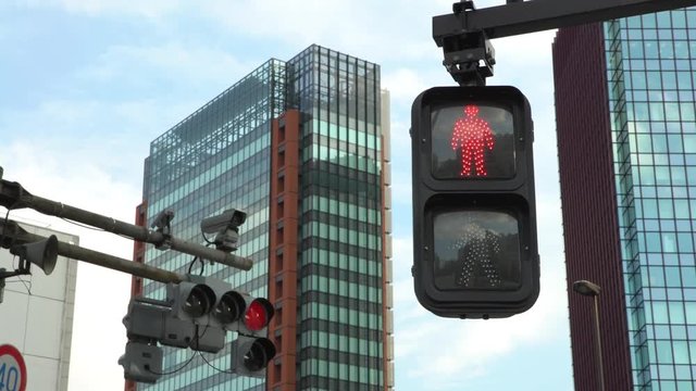 4K Asian pedestrian crosswalk sign Tokyo city traffic change from red to green color, light illuminated at day. Cross road intersection street Japan. Asia downtown-Dan
