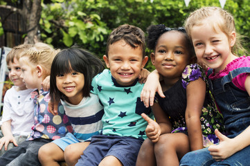 Group of kindergarten kids friends arm around sitting and smiling fun - Powered by Adobe