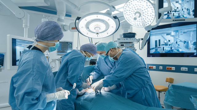 Medical Team Performing Surgical Operation in Bright Modern Operating Room