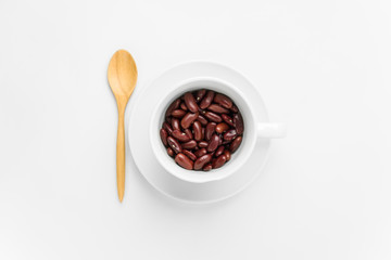 Red bean in white cup and wooden cutlery on a white isolated background.