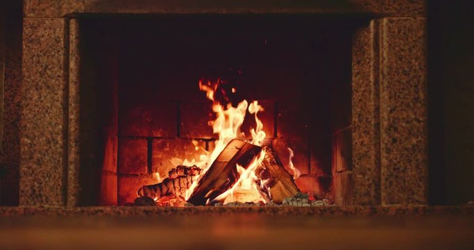 Slow motion fireplace burning. Warm cozy fireplace with real wood burning in it. Slow motion 120 fps. 4k graded from RAW. 