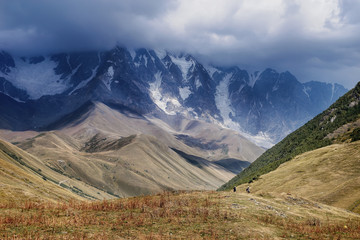 Snow-covered mountains of the Caucasus. Mountain landscape with tourists. Travel to Georgia.